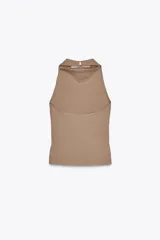 Top color beige de cuello halter y hombros descubiertos, con espalda descubierta, bajo con aberturas laterales y cierre en cuello con botones.