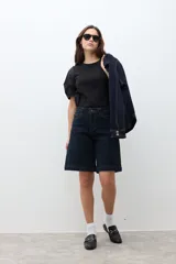 Bermuda de jean color azul oscuro, de corte recto y largo hasta la rodilla.