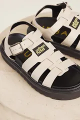 Sandalias de cuero sintético color lila con plataforma negra y tiras anchas cruzadas.
