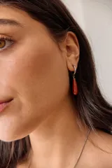 Aros colgantes de acero quirúrgico hipoalergénico con dije de piedra natural en forma de gota color azul oscuro.