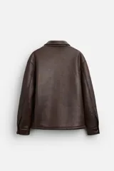 Sobrecamisa marrón de efecto piel con interior de borreguillo combinado a tono, de corte relaxed fit, cuello solapa, manga larga con puños abotonados, bolsillos de plastrón en pecho y laterales en cadera, efecto lavado y cierre frontal con botones a presión.