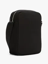 Bandolera Tommy Hilfiger negra con correa ajustable, cierre de cremallera, bolsillo interior con cremallera, bolsillo exterior con cremallera y logo metálico en la parte delantera.
