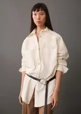 Camisa color crema de corte oversize con bordado floral en hombros y bolsillos.