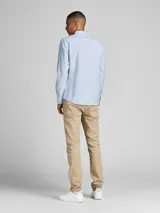 Camisa de vestir a rayas verticales celestes y blancas, de manga larga y cuello abotonado. Cierre con botones y corte slim fit.