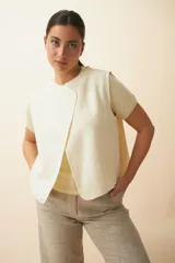 Chaleco marrón con solapas amplias y terminaciones envivadas. Diseño reversible y sin mangas.