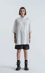 Camisa blanca de corte amplio con mangas cortas.