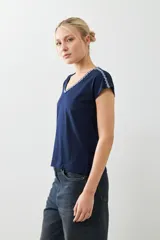 Remera blanca de algodón con escote en V y bordado en el borde. De corte recto y mangas cortas.