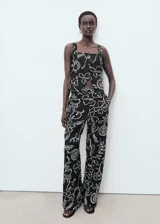 Top sin mangas con estampado de flores, cuello escotado, tirantes anchos y cierre delantero con tres botones.