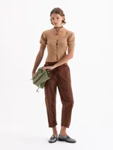 Top corto gris de punto acanalado, con escote redondo, manga corta abullonada y cierre frontal con tres ganchos decorados con piedras.