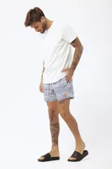 Short de baño con estampado de hojas de palmera en tonos beige, verde y naranja.