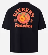 Remera negra de algodón con estampa de duraznos y texto "Bieber's Peaches" en color naranja.