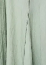 Vestido midi color verde menta, con escote en V, manga corta y diseño evasé. Presenta detalles de costuras y cierre de cremallera en la parte posterior.