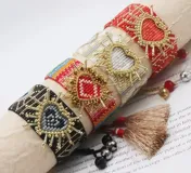 Set de pulseras tejidas con cuentas de colores y dije de corazón dorado.