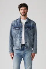 Campera de jean celeste, corte recto, con cuello clásico, cierre frontal con botones metálicos, bolsillos con solapa abotonados en el pecho y bolsillos laterales.