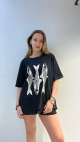 Remera blanca de algodón de corte oversize con estampado de tres peces rojos.