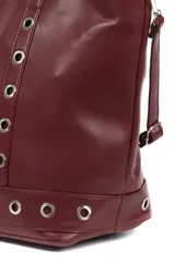 Bolso tipo shopper negro de cuero sintético con doble asa de hombro y correa bandolera desmontable. Presenta ojales metálicos plateados en los laterales y en la base.