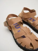 Sandalias romanas color verde oliva, con tiras entrecruzadas y hebilla lateral. Suela de goma negra con plataforma de 3cm. Fabricadas en cuero vacuno.