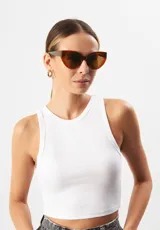 Gafas de sol con forma de ojo de gato, montura de acetato biodegradable color verde y lentes de PMMA reciclado color negro.