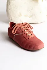 Zapatillas acordonadas color beige con detalles en blanco.