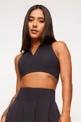 Top deportivo negro con cuello polo y espalda deportiva. Confeccionado en poliamida de alto rendimiento con protección UV50+.