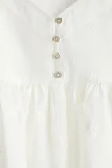Top blanco de breteles finos, escote en V y peplum con leve vuelo.