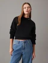Sweater negro de algodón y lana, con cuello alto y logo de Calvin Klein bordado en el cuello.