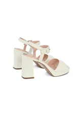 Sandalias de tacón color blanco con plataforma delantera y pulsera al tobillo.