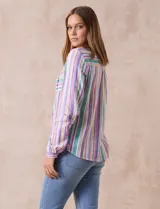 Blusa de lino estampada a rayas verticales de colores blanco, verde, lila, amarillo y rosa. Tiene cuello a la base con escote en V y abertura central con botones. Cuenta con dos bolsillos frontales y mangas largas regulables con presilla y botón. Marca Zac & Rachel.