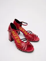 Sandalias rojas de charol con tiras cruzadas y taco cuadrado.