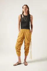 Pantalón jogger negro de nylon con elástico ancho en la cintura, puños elásticos ajustables y lazos laterales para fruncir.