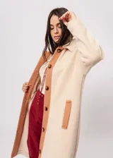 Tapado abotonado de paño pesado en color manteca, con cuello camisero y bolsillos laterales.