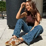 Championes deportivos de cuero vacuno, color beige con detalles en marrón tostado y cordones marrones. Tienen una suela de goma de 2,5 cm de altura en la parte trasera y 1,5 cm en la delantera, con una inclinación de 1 cm. La horma es de punta redonda, ancha y cómoda.