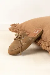 Mocasines tipo mule color beige, con detalle de cordones y ojales metálicos.