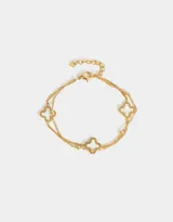 Pulsera dorada de doble cadena fina con dijes de flor de cuatro pétalos calados.