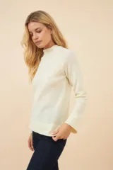 Sweater color crudo de lana fina sin teñir, con cuello alto y mangas largas. Diseño exclusivo de Don Baez, hecho en Uruguay.