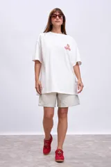 Remera blanca de corte holgado con estampa pequeña en el frente.