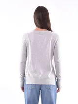 Buzo de tejido liso color negro, con escote redondo y manga larga. El puño y el ruedo son acanalados.