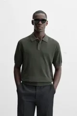 Polo de punto color verde oscuro, tejido en hilatura de algodón, de corte regular fit, con cuello solapa y cierre frontal de botonadura.