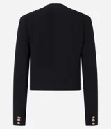 Saco negro de crepé con botones dorados diferenciados, mangas largas, cuello redondo y bolsillos con solapa.