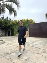 Conjunto negro tejido calado, compuesto por una remera de corte cuadrado y shorts.