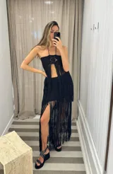 Top tejido de algodón color negro, con espalda descubierta y terminación en flecos.