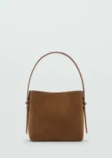 Bolso tipo tote de gamuza color marrón, con forro interior y cierre de botón magnético. Tiene asa de mano y asa de hombro ajustable.