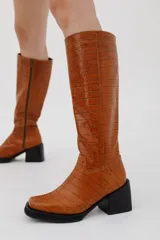 Botas bucaneras de cuero color negro, con caña alta y taco cuadrado.