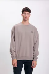 Buzo deportivo oversize color marrón, con diseño minimalista y mangas amplias.