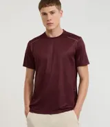 Remera deportiva de hombre color bordó con textura acanalada vertical y detalles reflectantes en los hombros.