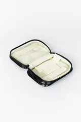 Necesser de forma rectangular con asa superior, confeccionado en material sintético negro brillante con efecto acolchado horizontal.