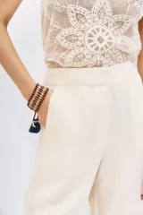 Pantalón palazzo de tiro alto, color negro, con caída fluida y largo al piso. Confeccionado en cupro y viscosa, presenta bolsillos laterales.