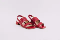 Sandalias rojas de cuero con taco bajo y tiras finas en el empeine y tobillo.
