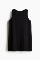 Vestido corto negro sin mangas, de corte evasé, con escote redondo, abertura de cerradura con botón oculto en la nuca y bajo recto. Parcialmente forrado.
