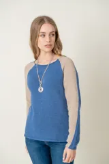 Sweater de lana azul con mangas ranglan color beige.
